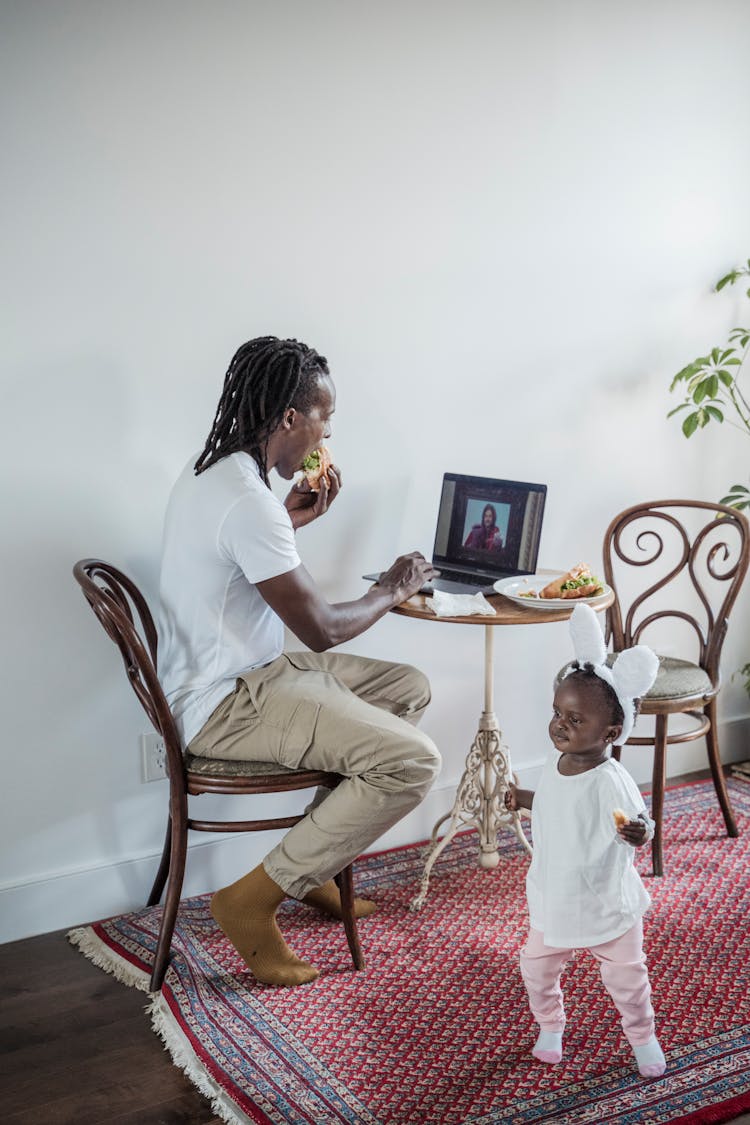 A Father Eating His Sandwich While Multitasking