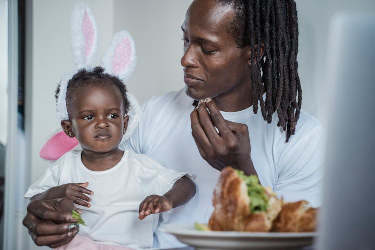 Father And His Baby Daughter Eating A Meal 