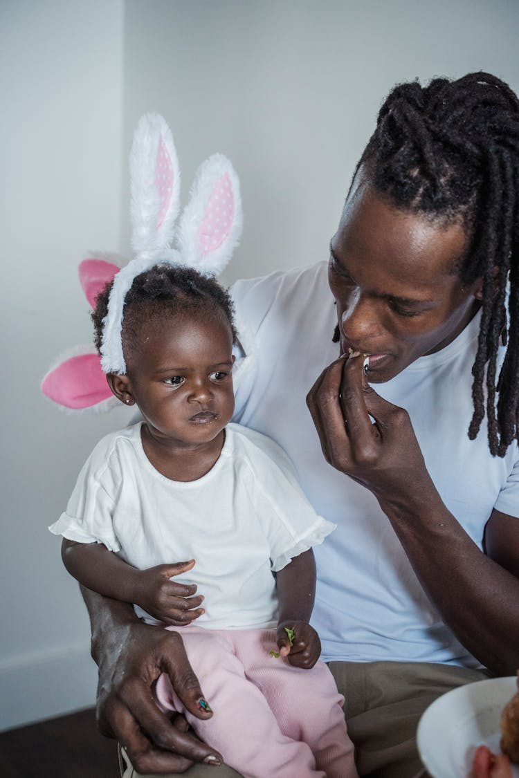 Father And His Baby Daughter Eating A Meal 