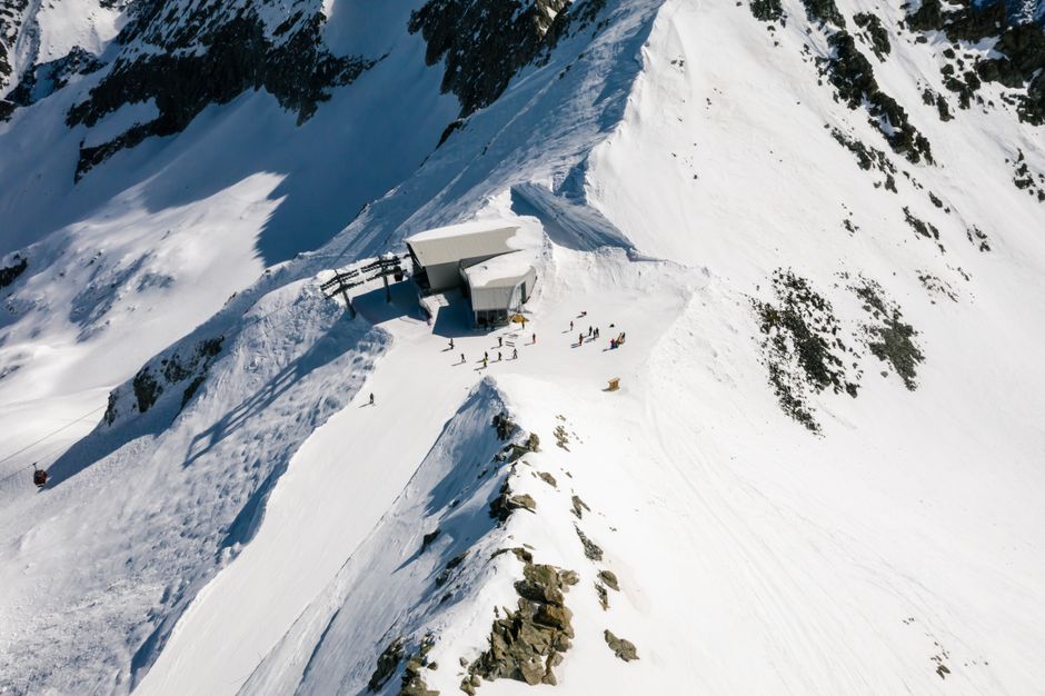 Explore a remote snowy mountain station with skiers and pristine winter landscapes.