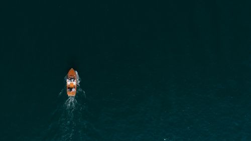 Free Aerial shot of a motorboat cruising through vast ocean waters, offering a serene sea view. Stock Photo