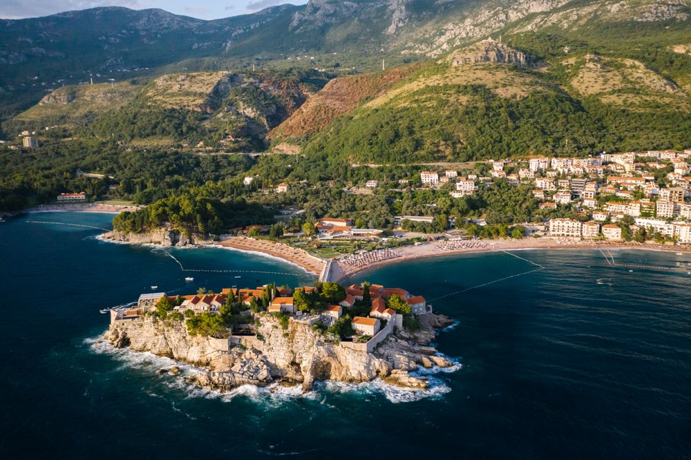 Vedere aeriană a insulei Sveti Stefan, cu istmul și coasta rivierei Budva în spate