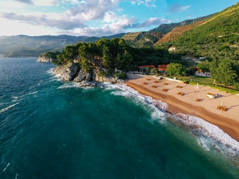A breathtaking aerial shot showcasing a tranquil beach with vibrant greenery, taken during the day.