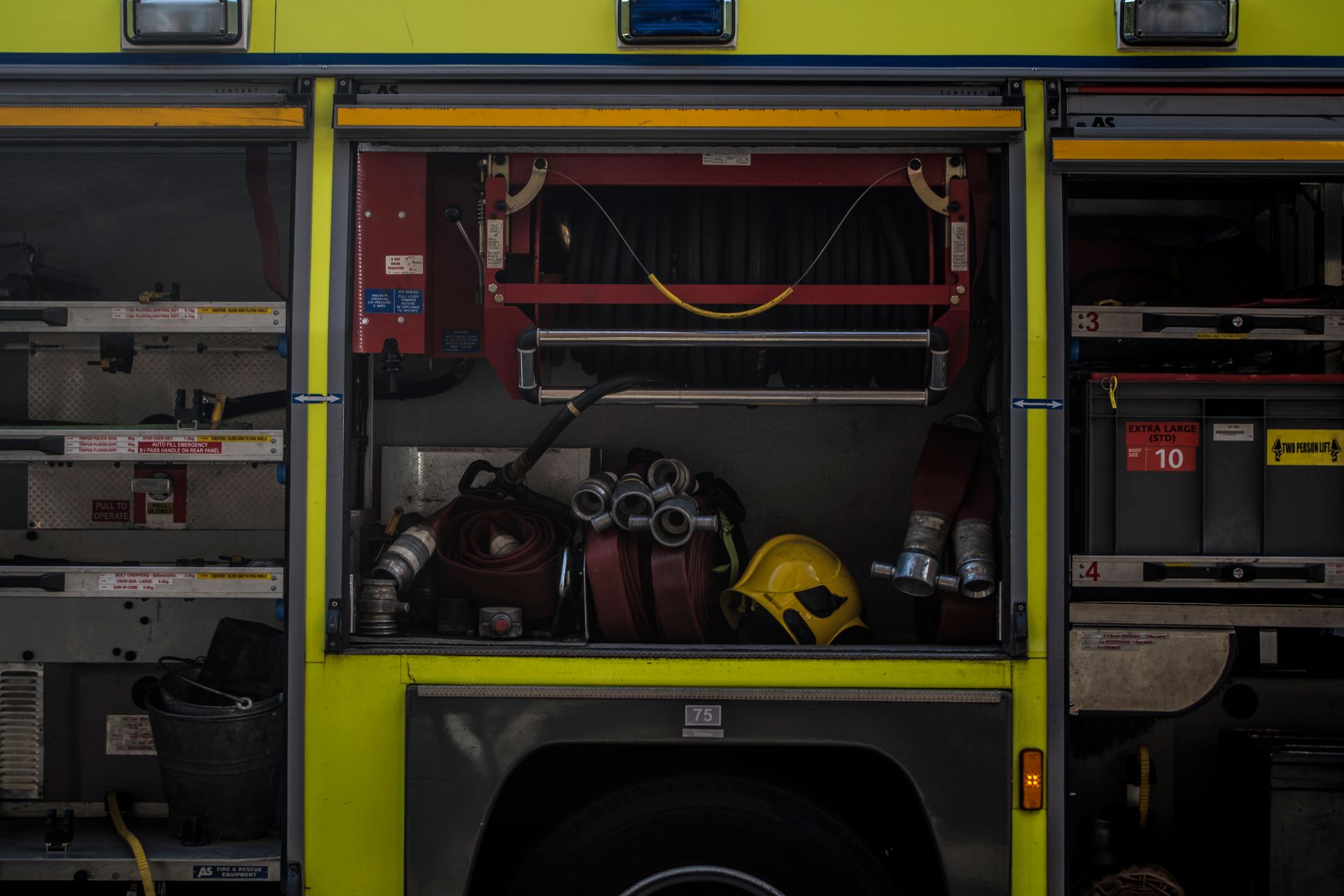 Close-up view of firetruck compartments featuring hoses and safety equipment in London, UK.