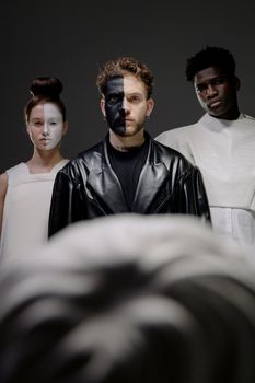 Artistic portrait with diverse individuals, blending fashion and conceptual themes.