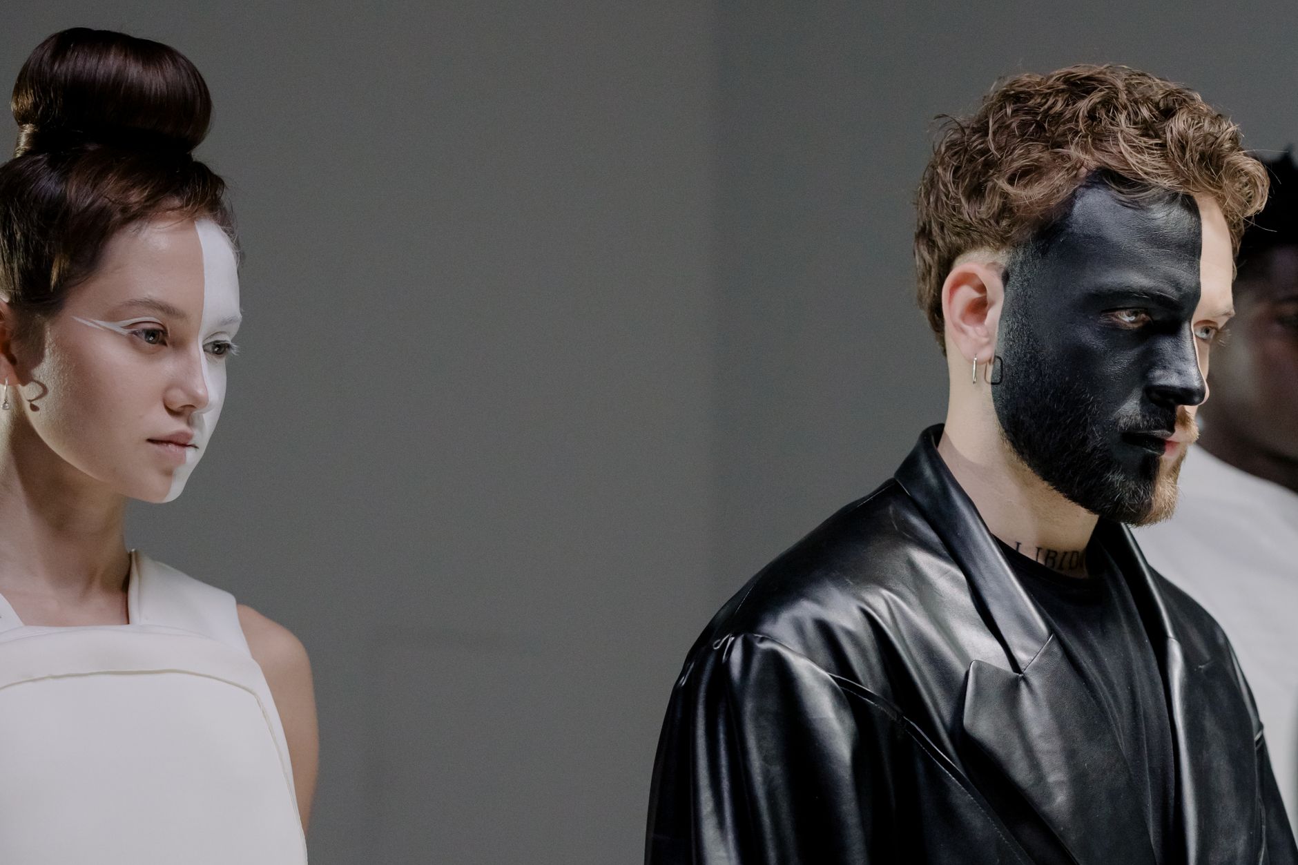 Stylish portrait of models with bold face paint and fashionable outfits.