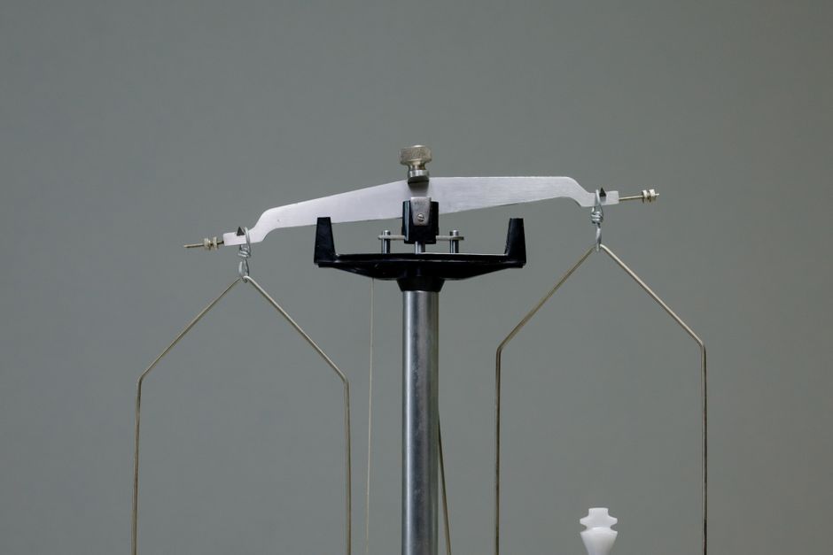Chess pieces balanced on a scale — comparing iboga microdosing versus flood dose requires understanding fundamentally different dose ranges and intended outcomes