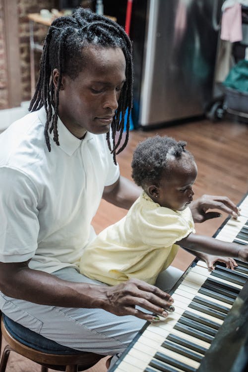 Free A Man Playing the Piano with His Daughter Stock Photo