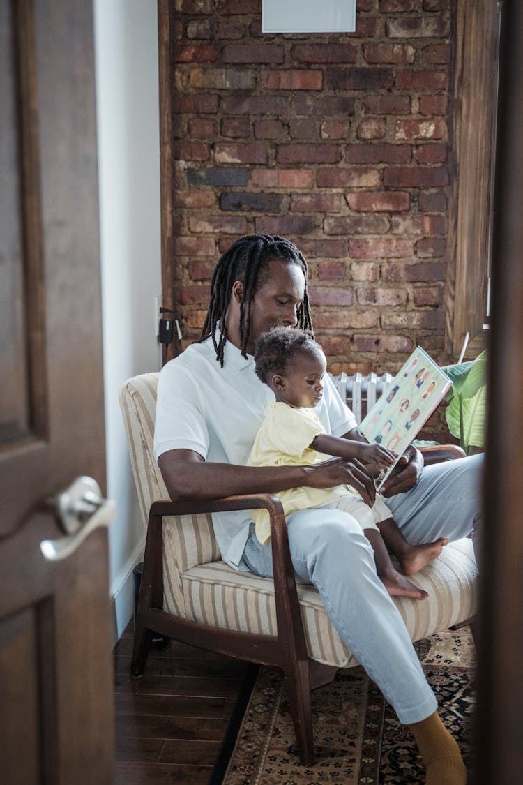 A Father Reading A Book To His Child