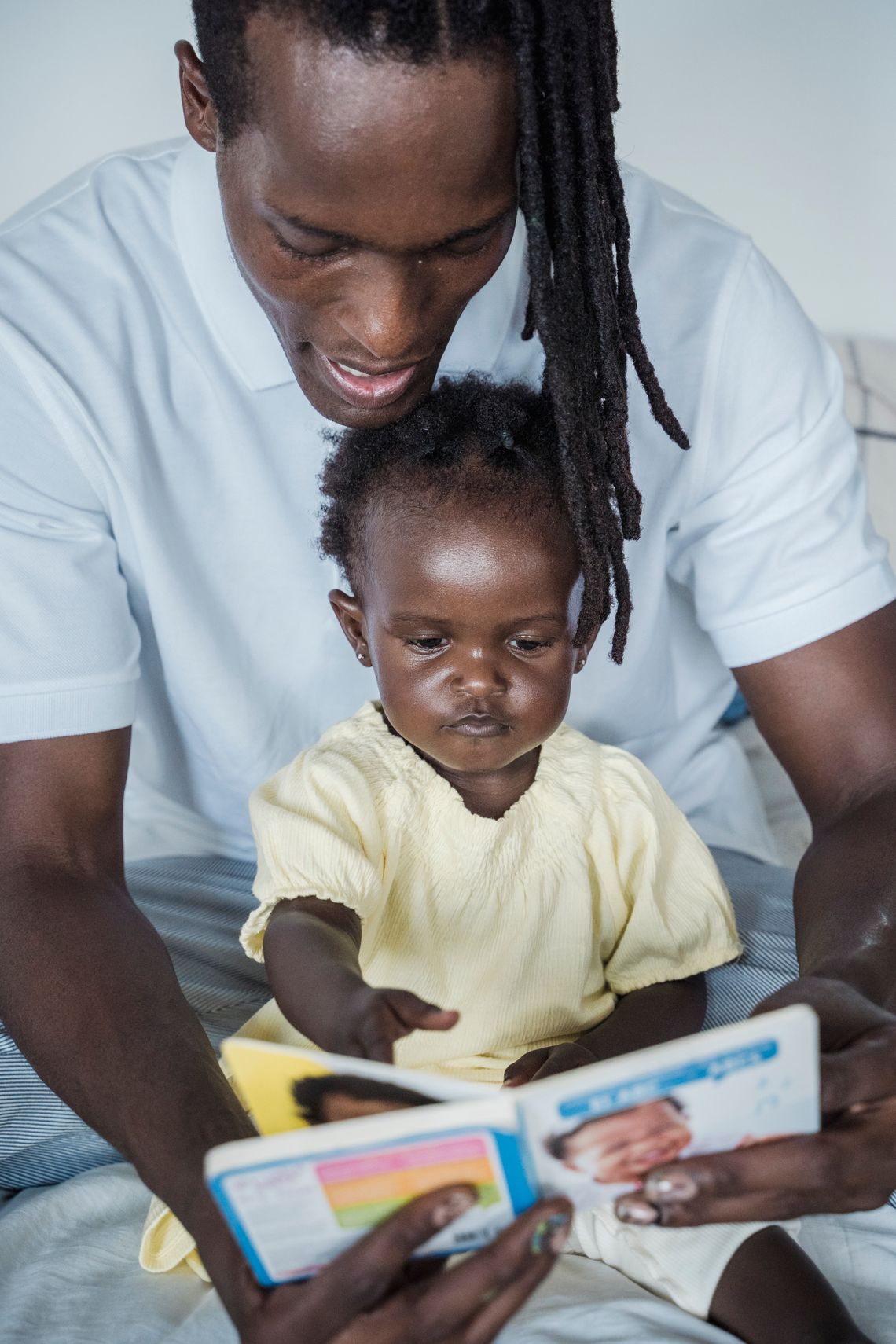 Father and child sharing a book and learning together indoors