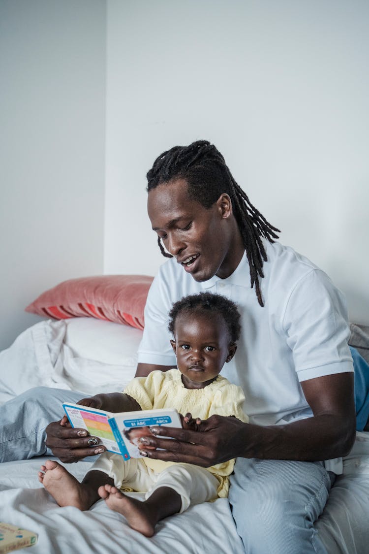 A Man Reading A Book To His Kid