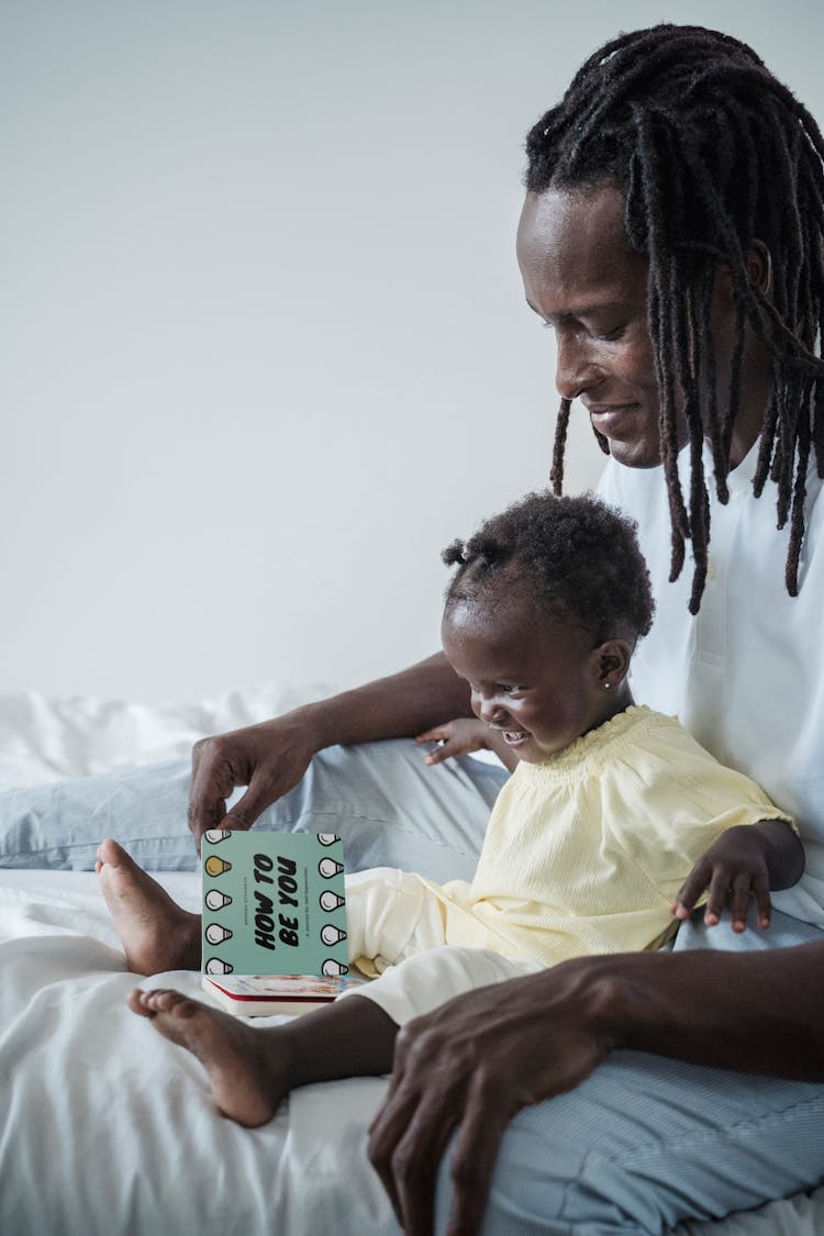 A Father Reading A Book To His Child