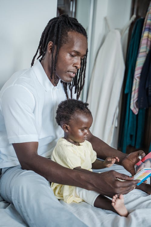 Free Tender moment of father and baby reading a book together indoors. Stock Photo