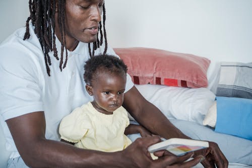 Father and His Child Sitting on the Bed