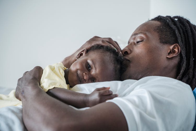 Close Up Of A Father Lying Down With A Baby Daughter