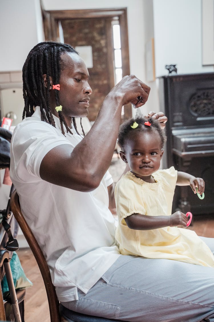 Man With His Baby Daughter Sitting On His Lap 