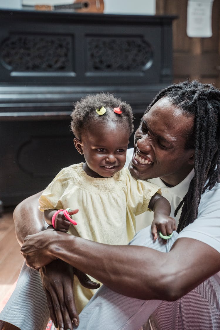 Father Hugging His Baby Daughter And Smiling 