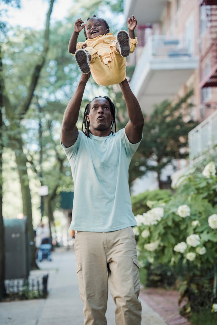 A Father Tossing His Daughter In The Air