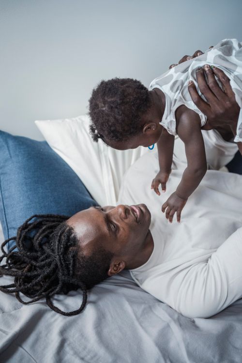Free An intimate moment of a father playing joyfully with his young child indoors. Stock Photo