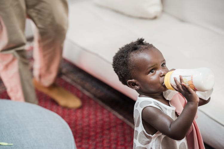 A Young Girl Drinking Milk Using Baby Bottle