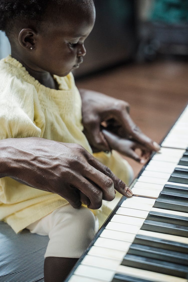 Father Teaching His Daughter To Play The Piano 