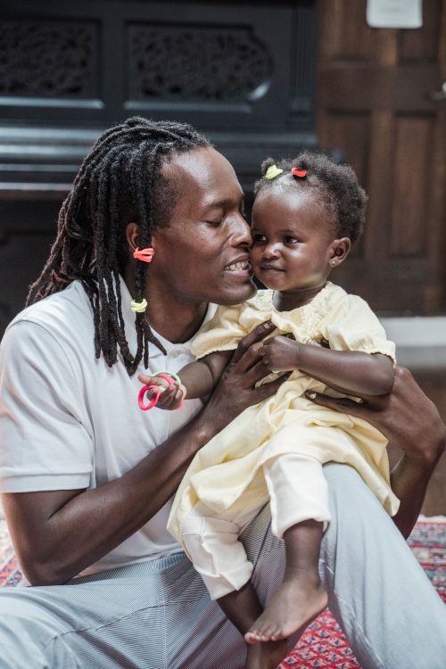 Free A father shares a tender moment with his young daughter in a cozy indoor setting. Stock Photo