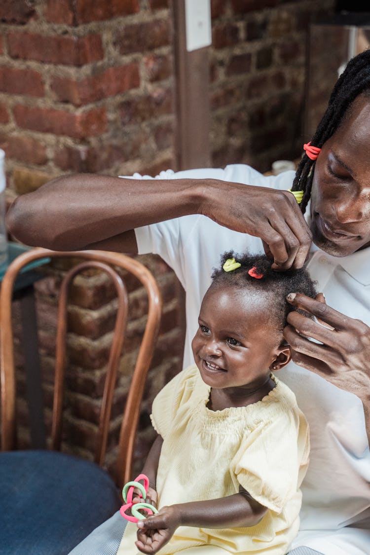 Man Putting Hair Clips On Her Daughter