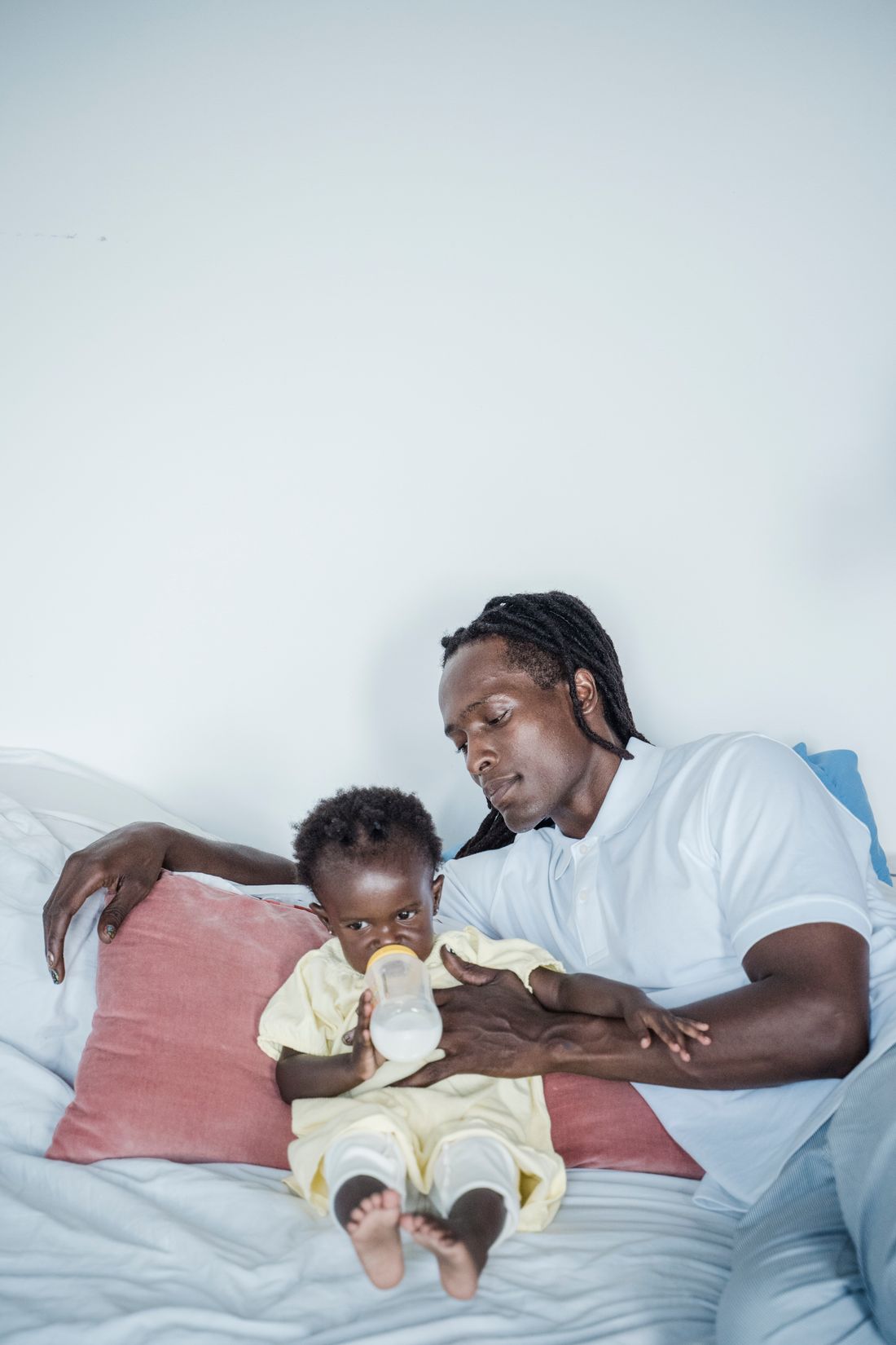 Tired father resting next to his baby