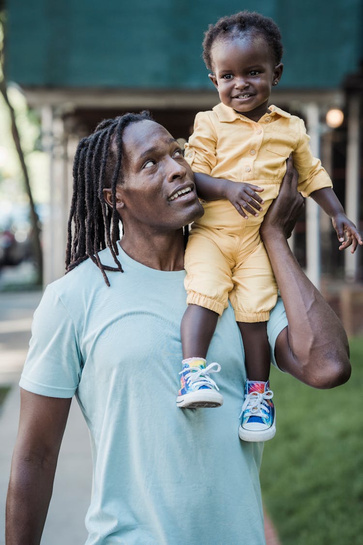 A Father Carrying His Child On His Shoulder 