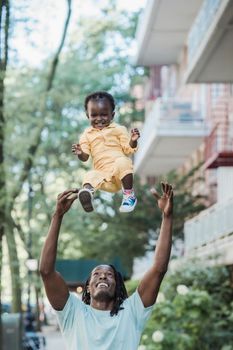 Man Throwing his Baby Son in Air