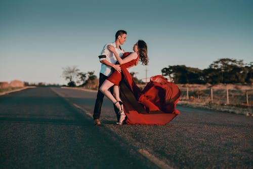 Pria Dan Wanita Melakukan Pos Dansa Di Jalan Beton Pada Siang Hari