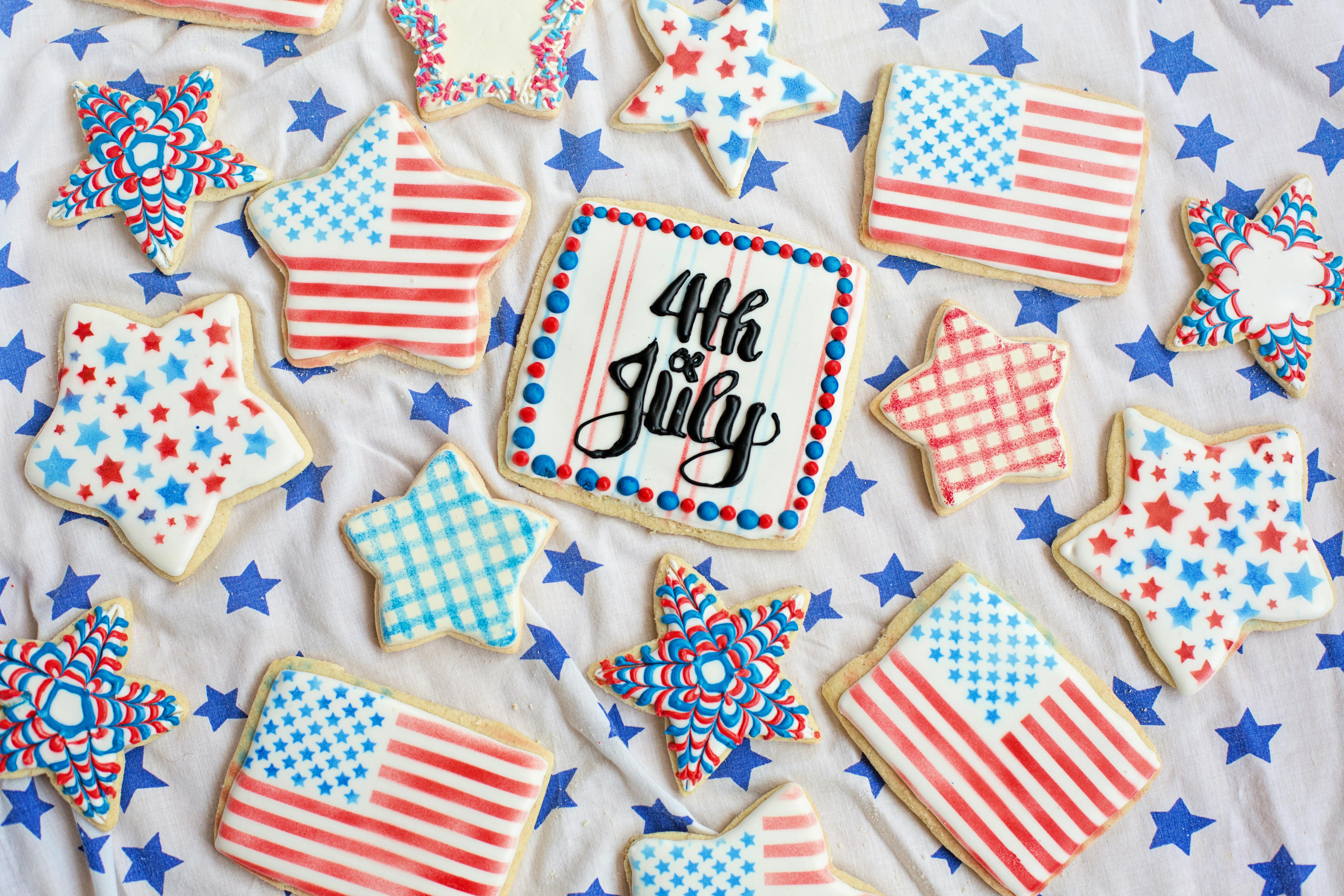 Patriotic cookies decorated with American flags and stars for Fourth of July celebration.