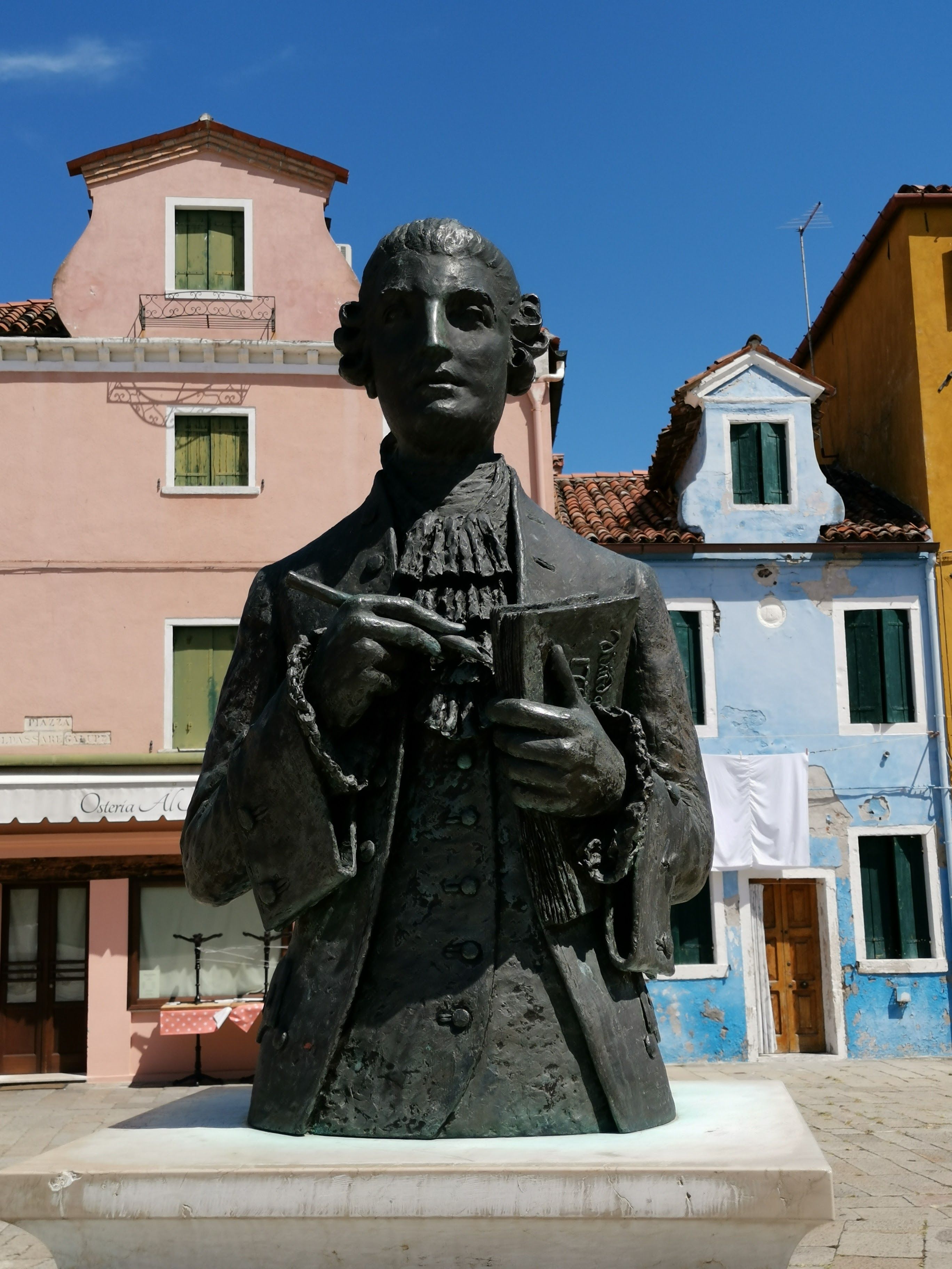 A Statue of a Person Near the Storefronts · Free Stock Photo