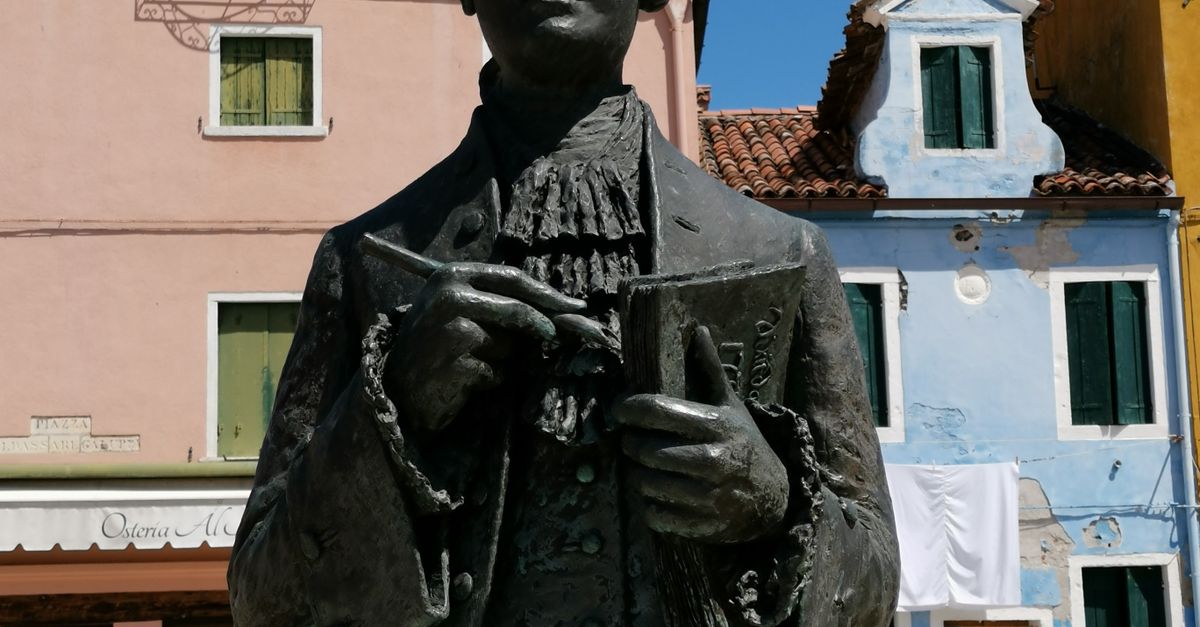 A Statue of a Person Near the Storefronts · Free Stock Photo