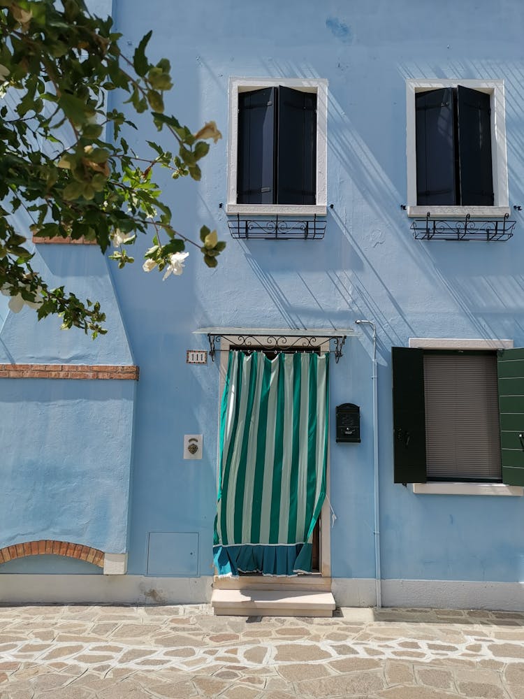 Blue Wall With Curtain Hanging On The Door