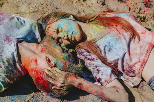 Woman and Man Lying on Ground at Holi Festival