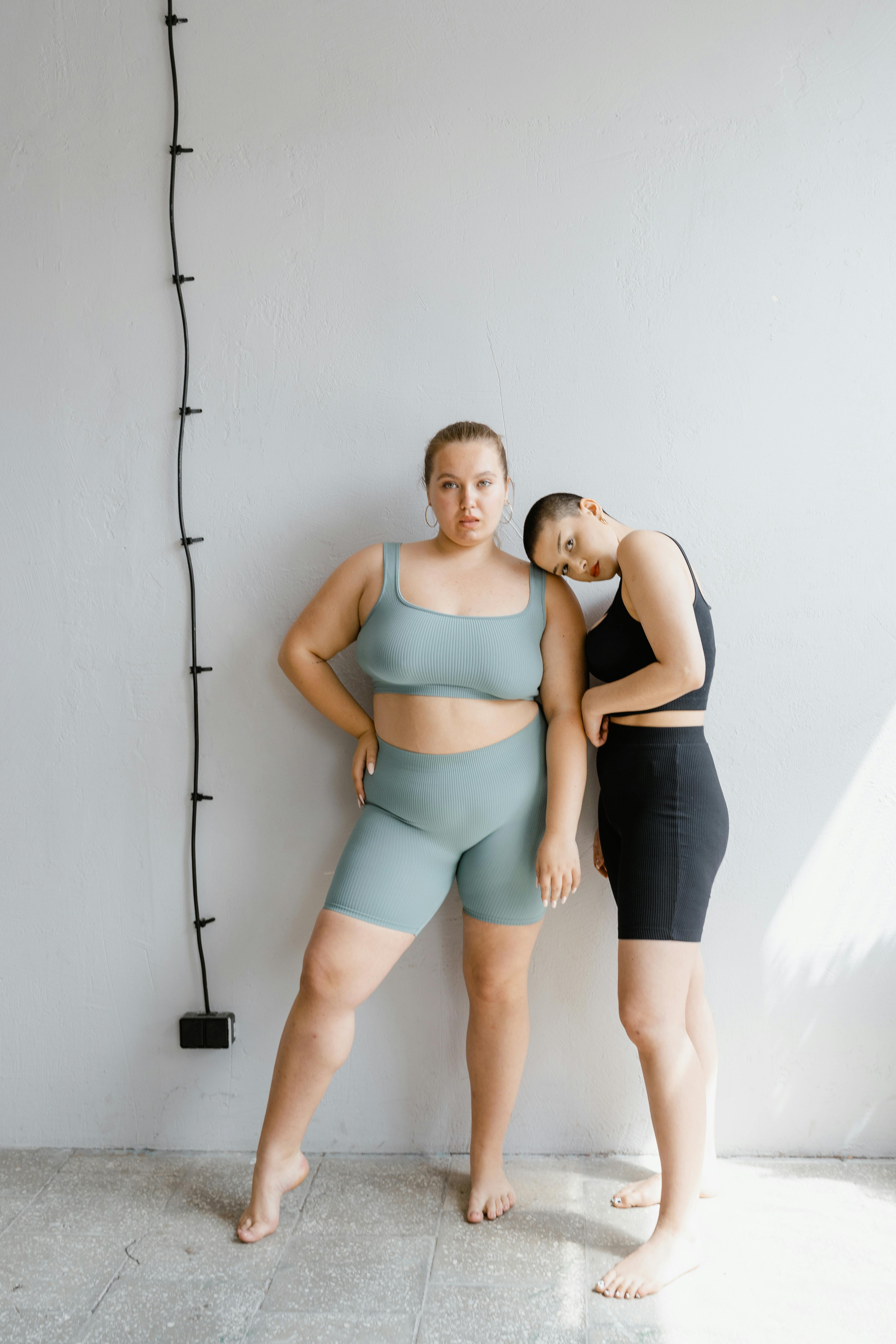 Diverse women in sportswear showcasing body positivity and confidence indoors.