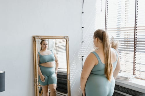 A Woman in big thighs Looking at Her Reflection Stock Photo