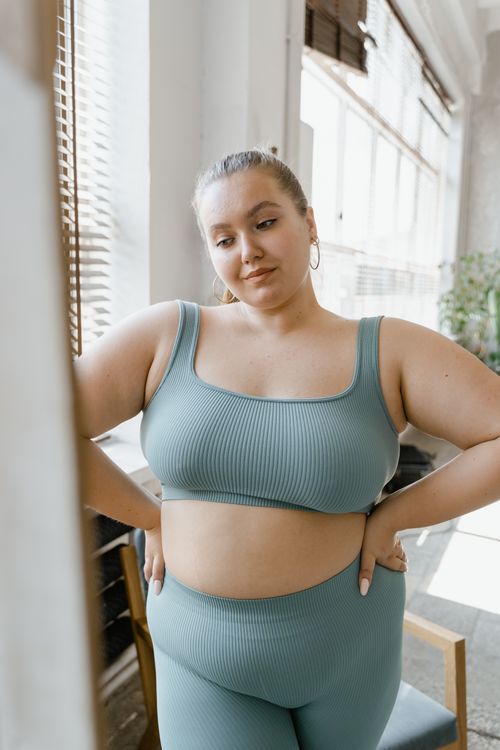Free Plus size woman embracing body positivity in stylish activewear, indoors. Stock Photo