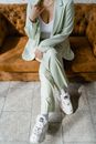 A Person Wearing a Green Suit with White Undershirt Sitting on the Couch