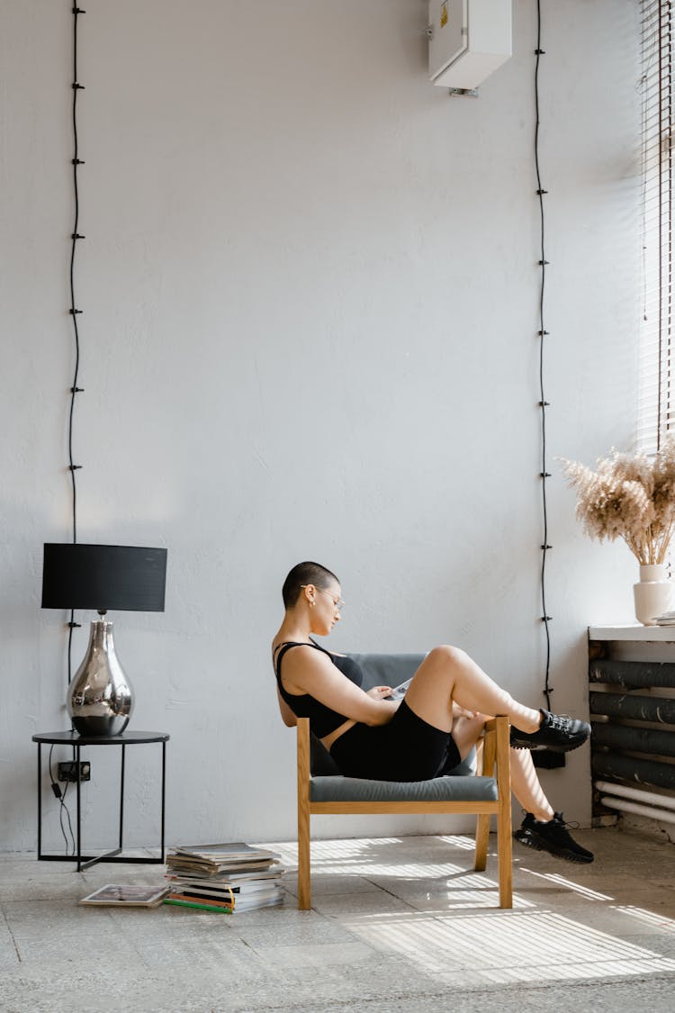 Woman Wearing Rubber Shoes Sitting On A Chair 