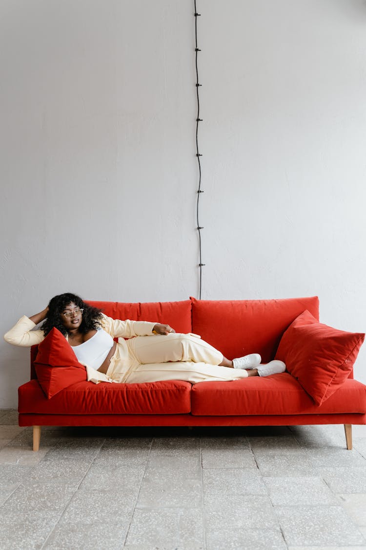 Woman Lying On Red Sofa