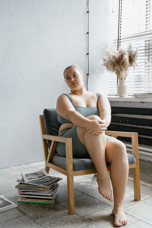 Free A serene portrait of a confident woman in a minimalist room, enjoying leisure time. Stock Photo
