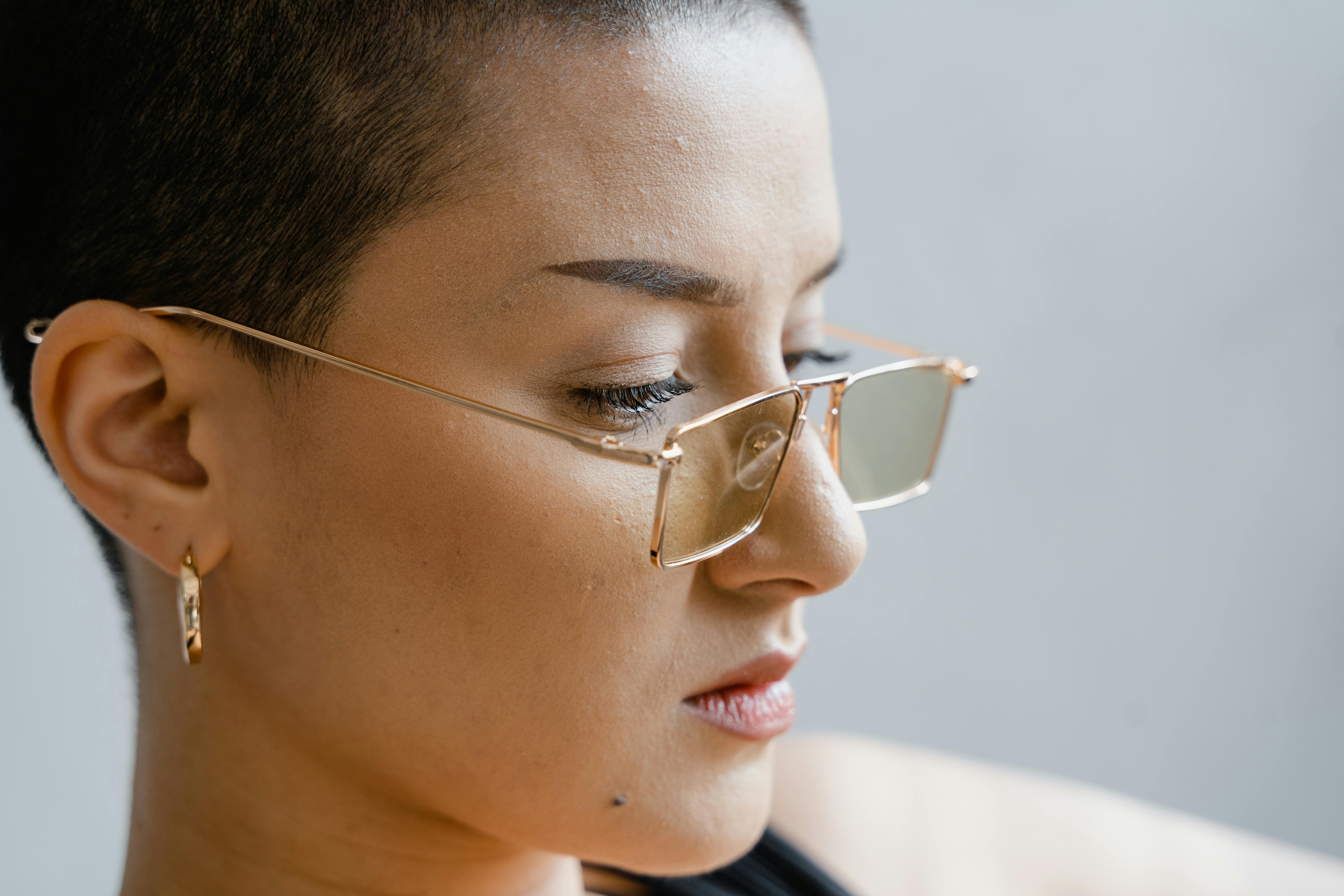 close up of woman wearing gold frame eyeglasses