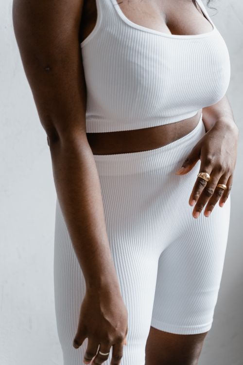 Free Elegant close-up of a woman in white ribbed activewear showcasing minimalist fashion. Stock Photo