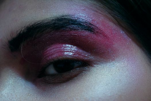 Close-up image showcasing bold pink eyeshadow makeup on a South Asian adult's eye.