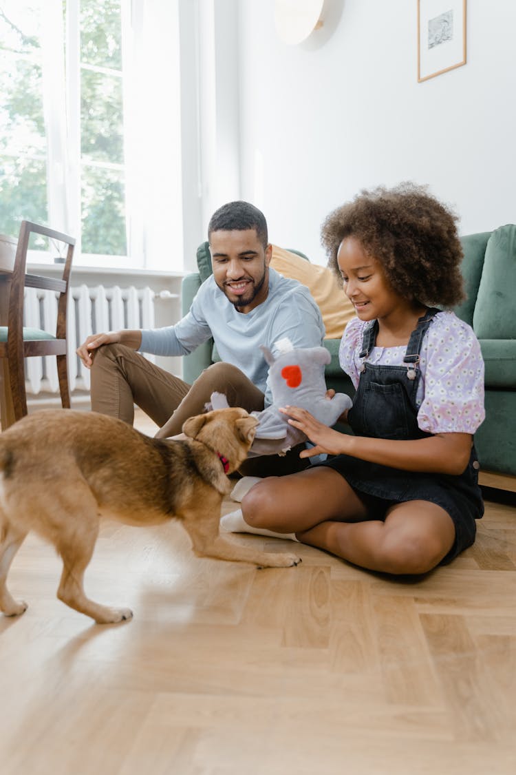 Man And Woman Playing With Their Dog