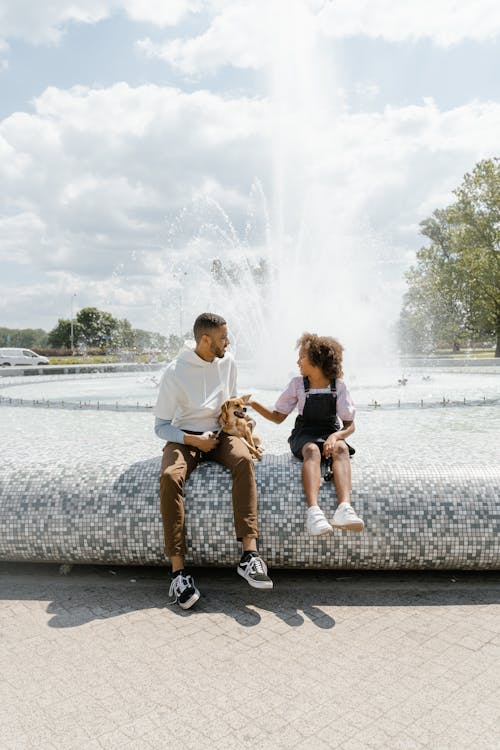 A Father and Daughter with Their Dog in the Park