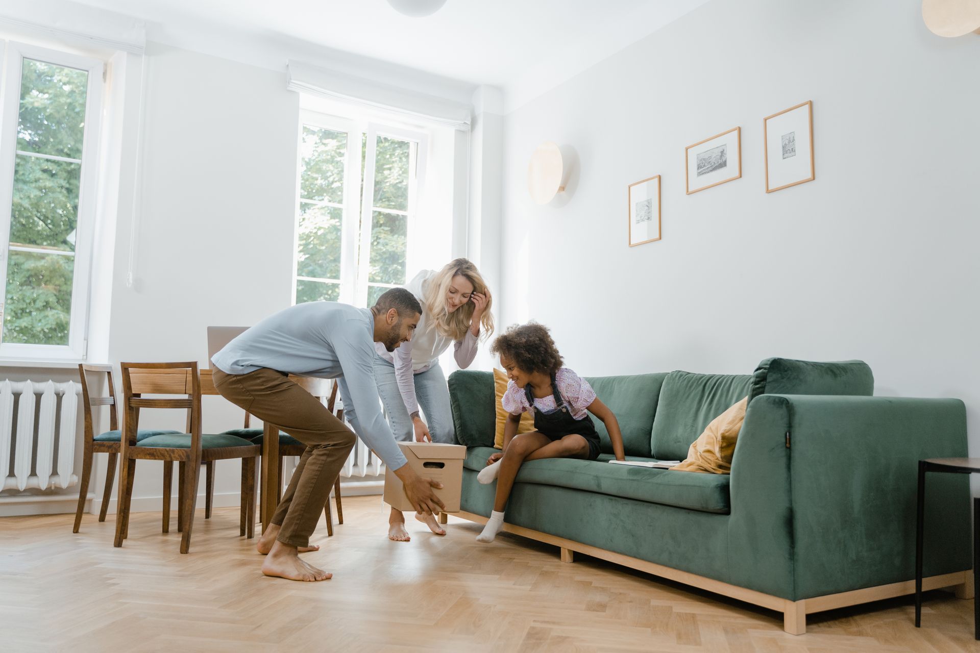 A cheerful family unpacks boxes together in their modern living room.