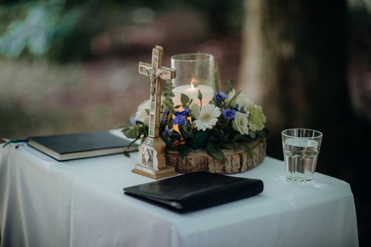 Altar Crucifix Beside Flowers With Lighted Candle 